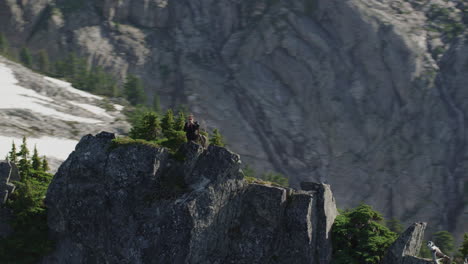 fotógrafo toma una foto telefónica en la cresta de la montaña y lanza shaka, tim durkan helicóptero de seguimiento amplio en sentido contrario a las agujas del reloj órbita lenta