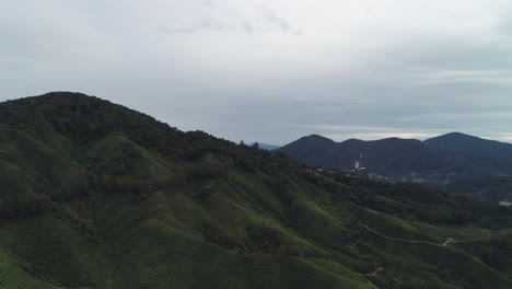 Dramatic-cloudy-sky-at-green-tropical-highlands-in-Asia,-aerial