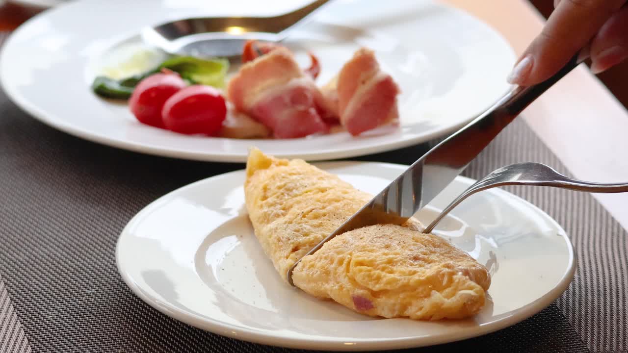 Tagliare un'omelette soffice su un piatto.