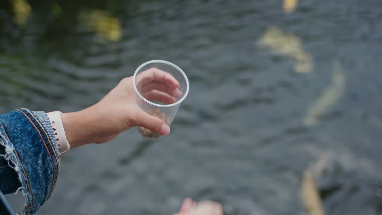 플라스틱 컵 을 들고 있는 여자 손 의 근접적 인 모습
