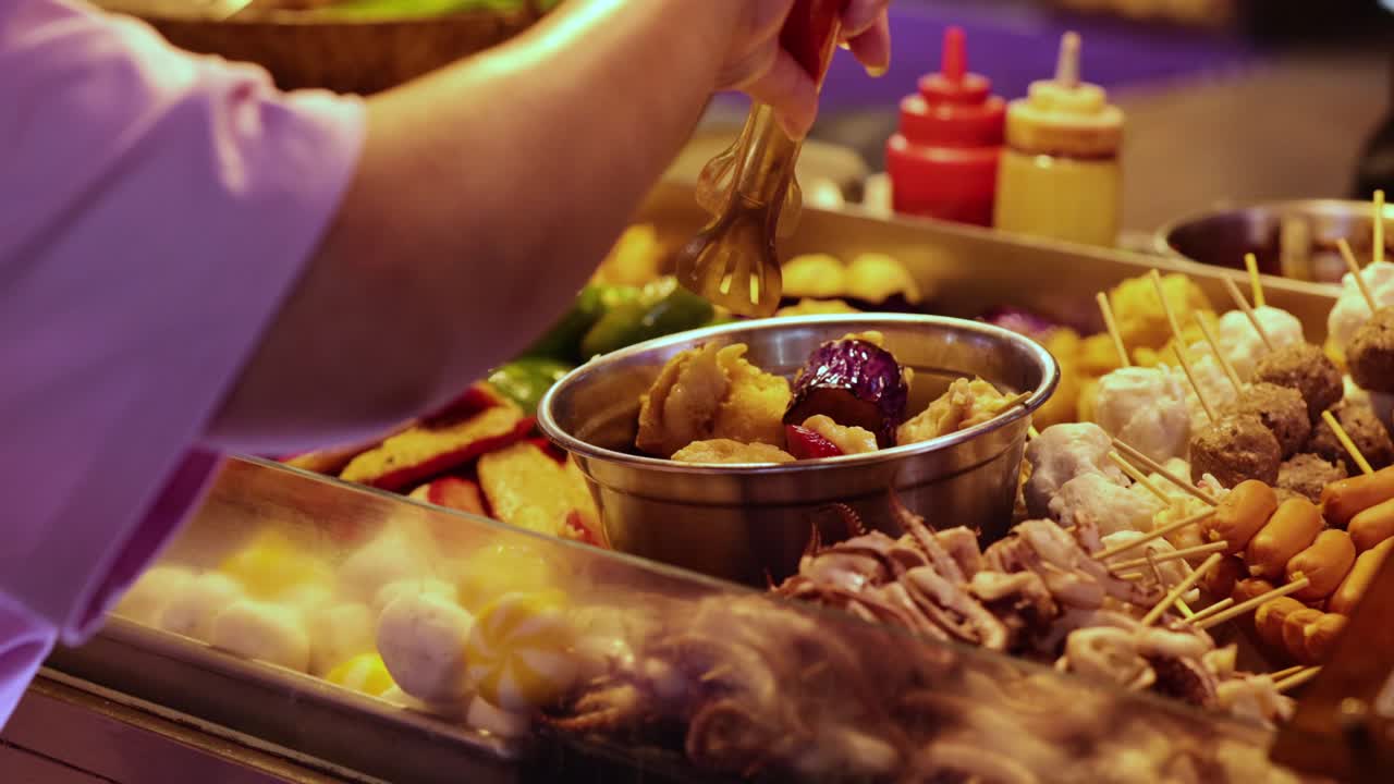 vendedor preparando salchichas en un puesto de comida