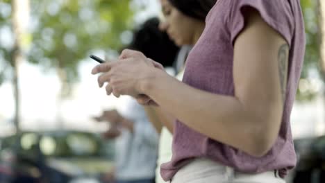 Primer-Plano-De-Una-Mujer-Usando-Un-Teléfono-Inteligente-Mientras-Camina