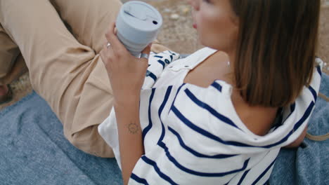 hand holding reusable coffee cup closeup. serene girl drinking morning beverage