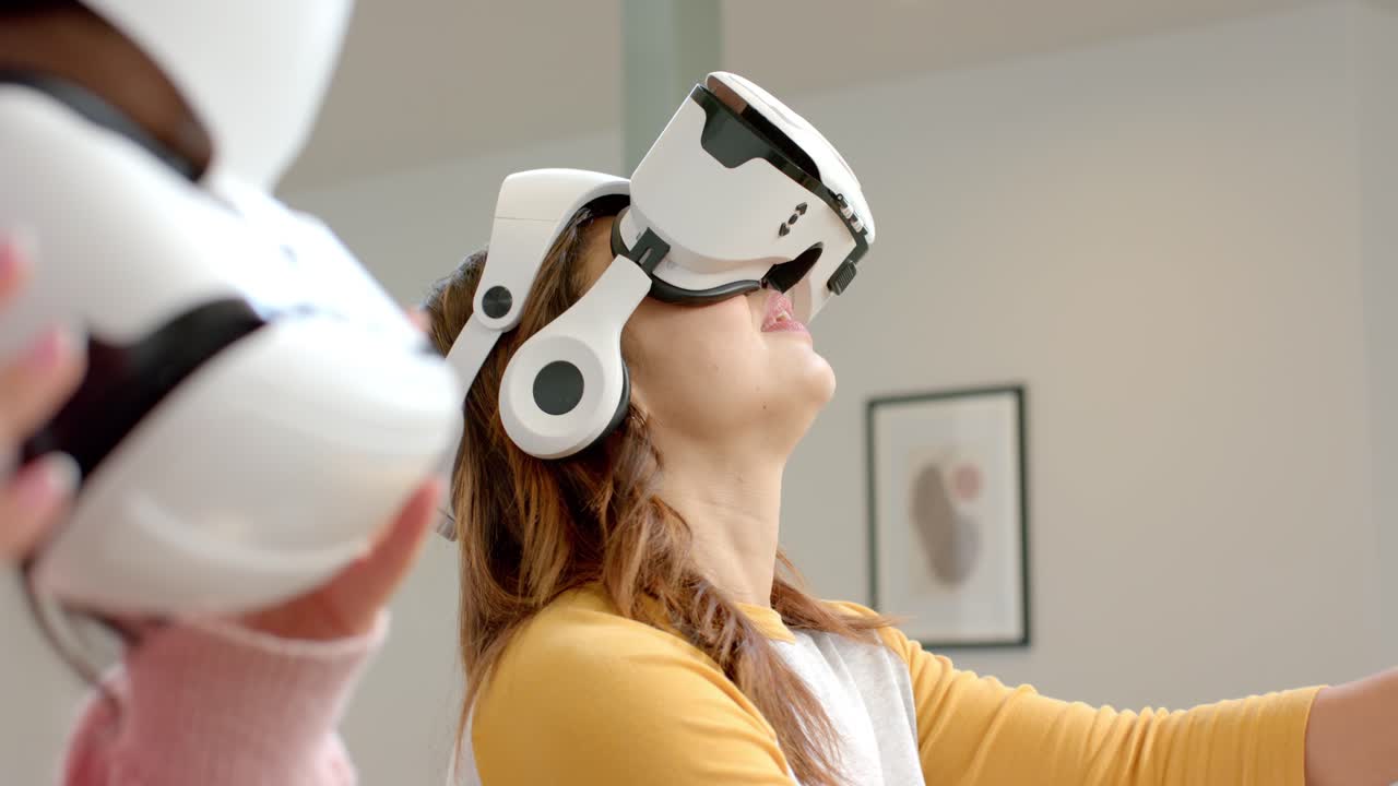 Mid adult woman entering room placing VR headset near artwork exploring virtual scene, copy space
