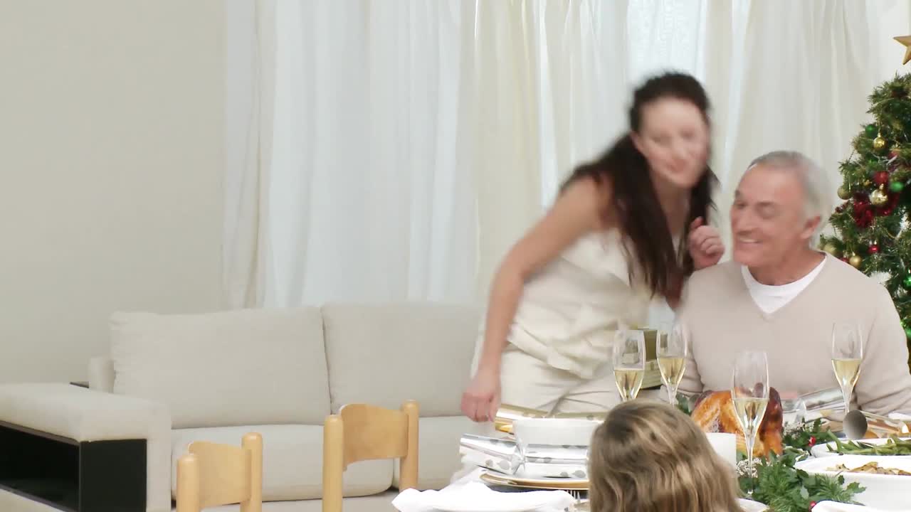 어머니 는 크리스마스 에 가족 에게 칠면조 를 보여 주고 있다