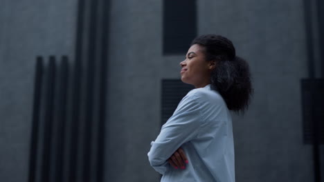 proud woman standing alone outdoors portrait. girl pose inspect modern building.