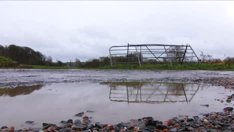 las gotas de lluvia golpean un charco frente a una puerta en el campo