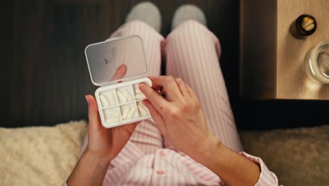 woman taking medicine in pajamas