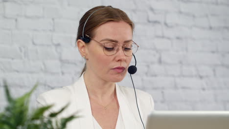 a technical support customer service worker talking into a headset in an office