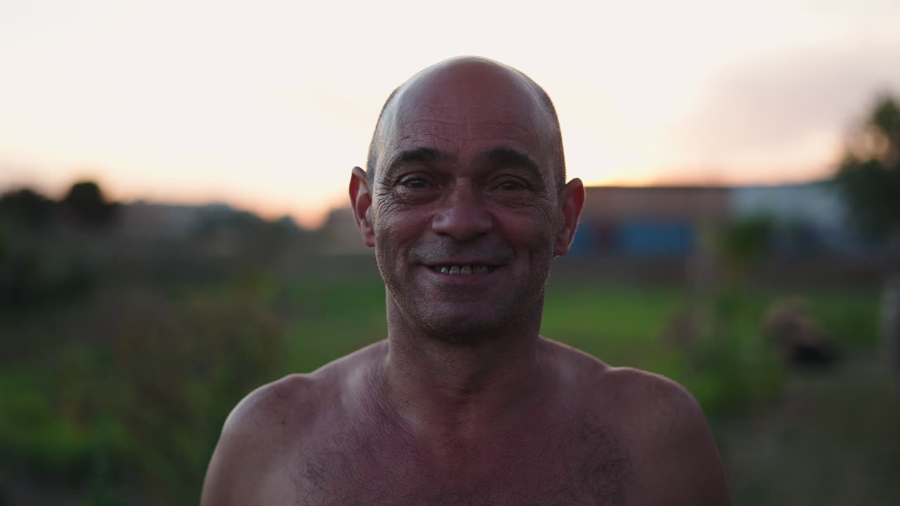 Retrato autêntico de um homem feliz sorrindo ao pôr do sol