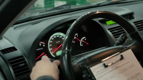 mano del mecánico tomando notas bajo en el coche y verifica las luces