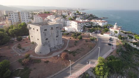 4K-aerial-view-of-the-medieval-defensive-tower-of-Oropesa-del-Mar-and-its-Lighthouse-by-the-Mediterranean-Sea,-Spain