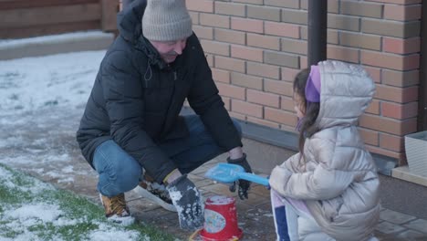 grandfather and granddaughter having fun in the snow