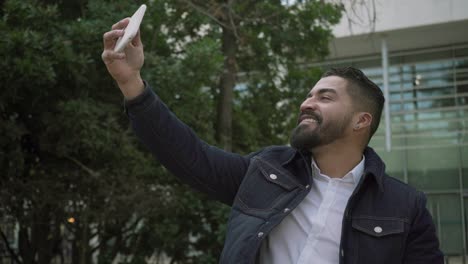 hombre alegre teniendo chat de video en la calle