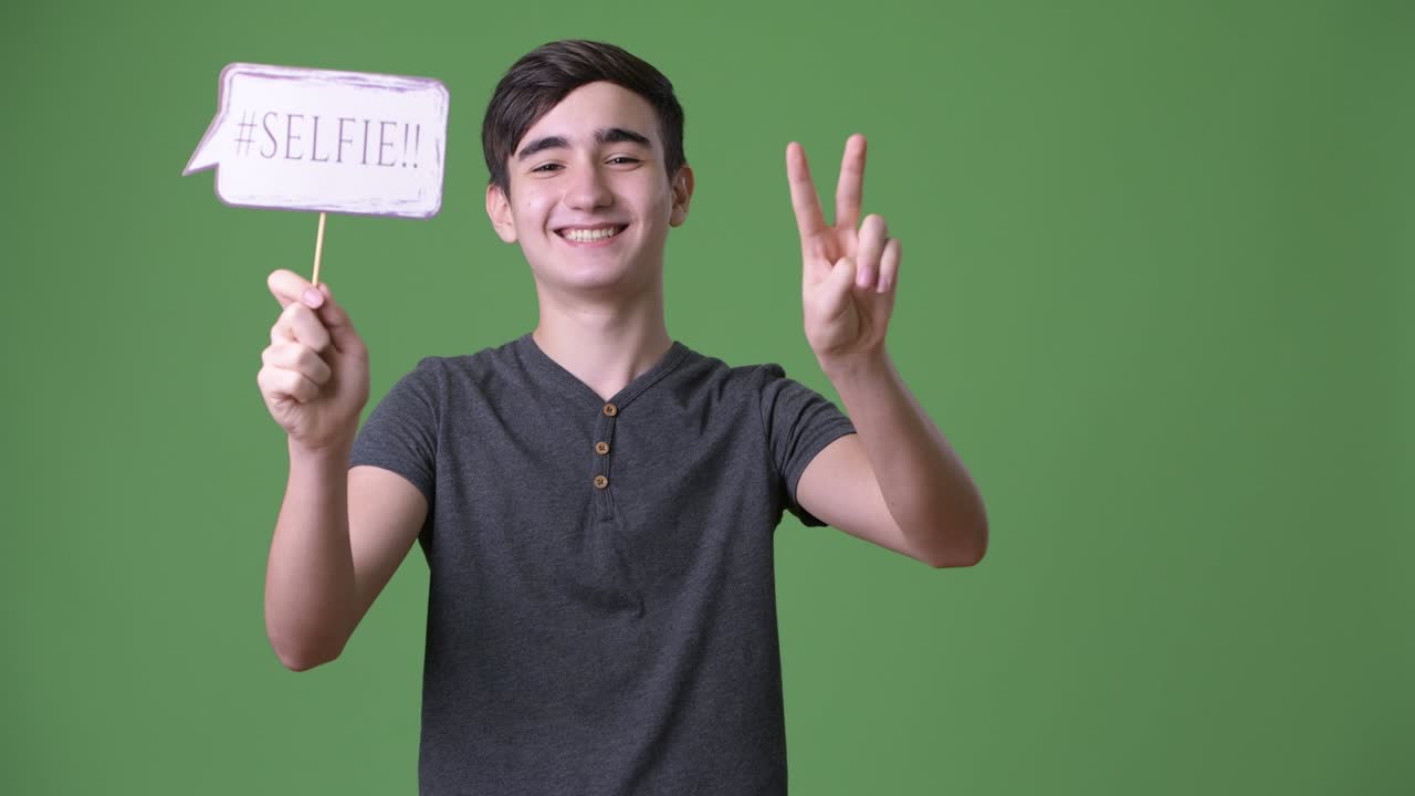 초록색 배경에 젊은 잘생긴 이란 십대 소년