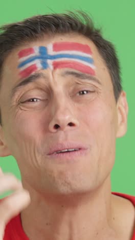 very nervous man supporting norwegian team during a difficult match