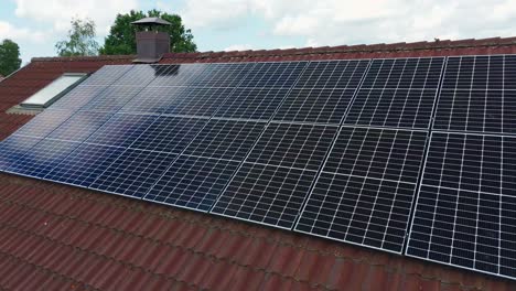 Drone pulls back and tilts up to reveal a photovoltaic array on a red tile roof, symbolizing clean, efficient renewable energy in bright daylight
