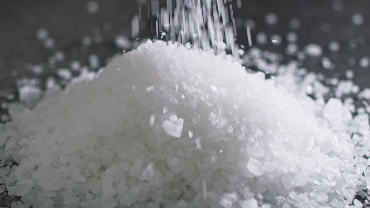 어두운 배경 에 공중 에 있는 소금 알 의 클로즈업 비디오