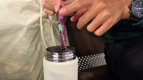 adding instant drink to a thermos