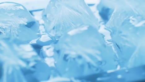 a clear view of ice cubes melting in an ice tray filled with water, highlighting the coolness and refreshing nature of frozen water in a close-up perspective