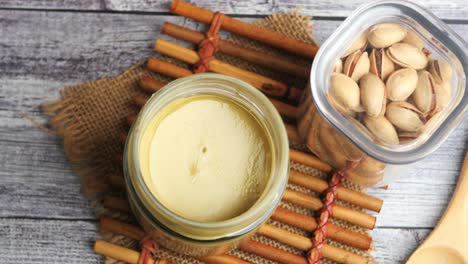 pistachio paste and nuts on a rustic wooden background