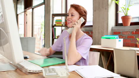 Mujer-De-Negocios-Casual-Hablando-Por-Teléfono-En-Su-Escritorio