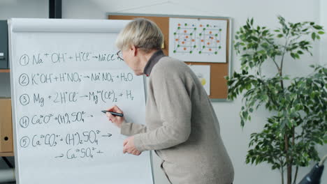 chemistry class - teacher explaining formulas on whiteboard