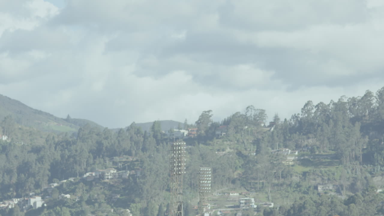 Close-up of two glasses gently clinking as they transition from initial blur to sharp focus, with a landscape visible through a window