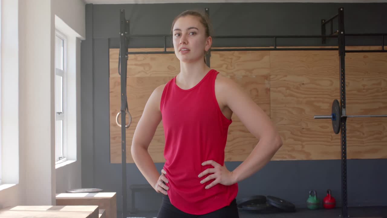 피곤하고 변하지 않은 백인 여성이 체육관에서 크로스 트레이닝에서 휴식을 취하는 초상화, 느린 동작