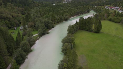 Panorama-shot-of-Soca-Valley-group-of-green-kayaks-paddling-in-river,-aerial