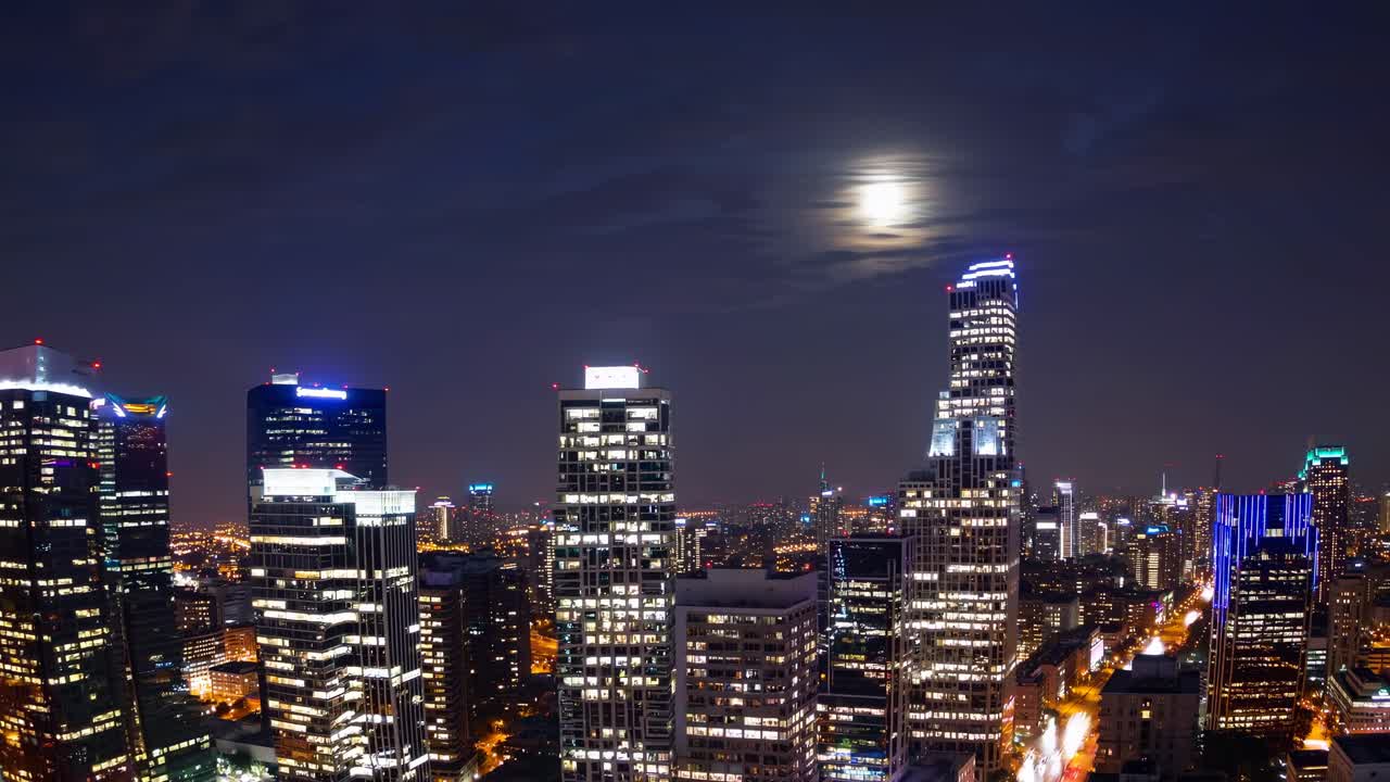 Vídeo aéreo captura um horizonte urbano vibrante ao entardecer, exibindo arranha-céus iluminados.