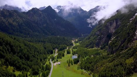 dolomite peaks in northern italy with a grassy canyon below on a clear winter day, aerial drone approach