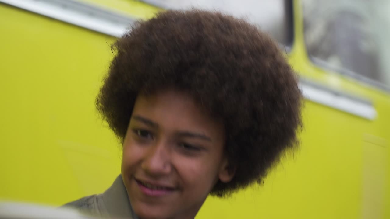 счастливый молодой афроподросток с энтузиазмом играет на барабанах