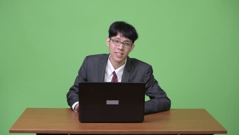 young stressed asian businessman getting bad news