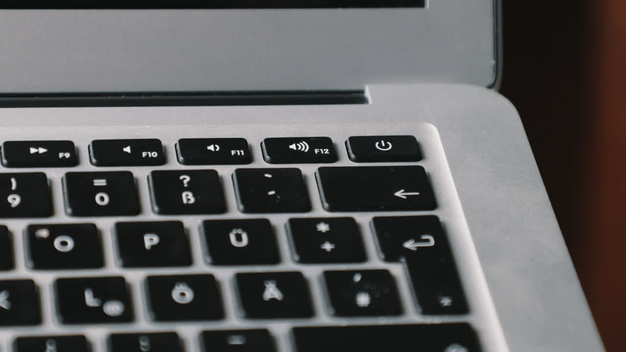 dedo en el botón de encendido de una nueva computadora portátil encendiéndola