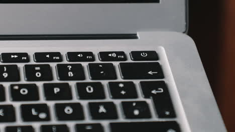 dedo en el botón de encendido de una nueva computadora portátil encendiéndola