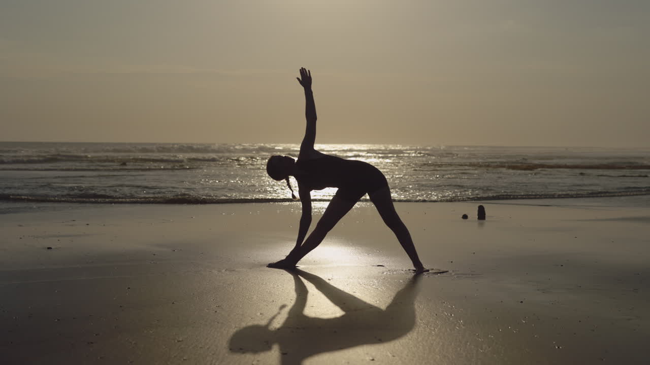 Yoga sulla spiaggia al tramonto