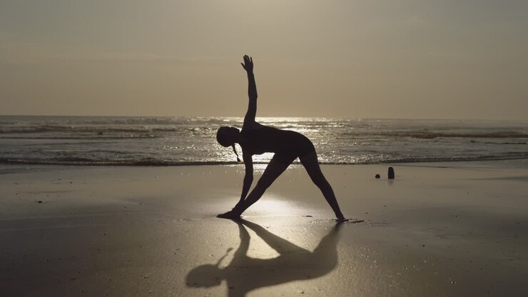 Yoga sulla spiaggia al tramonto