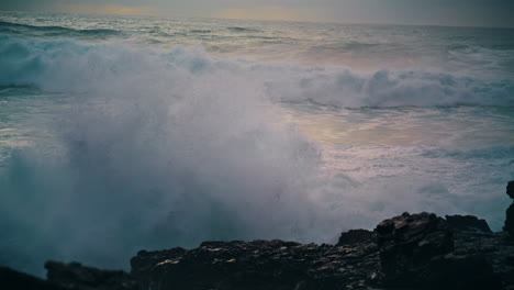 las olas espumosas rompiendo las piedras de la costa de cerca.