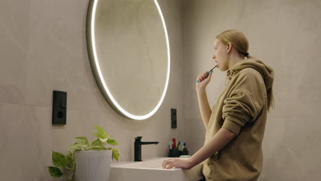 woman brushing teeth in bathroom