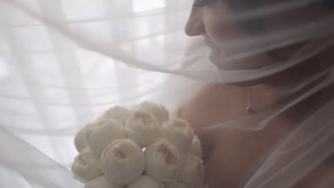 hermosa novia en vestido de novia blanco sosteniendo un ramo de flores blancas