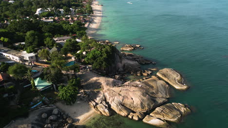 Aerial-birds-eye-shot-of-Lamai-beach-with-Rocks-and-cruising-boat-on-the-ocean-at-sunset,-Koh-Samui,-Thailand