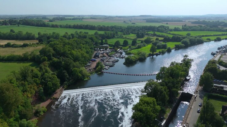 Paesaggio aereo ripreso da drone di Gunthorpe Weir e del fiume Trent nel Nottinghamshire, con canale navigabile e tranquilla campagna rurale e bagliore del tramonto estivo serale
