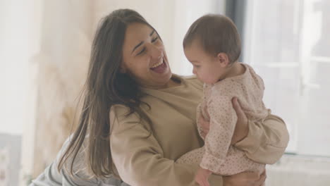 feliz pareja joven en pijama jugando con su bebé en casa