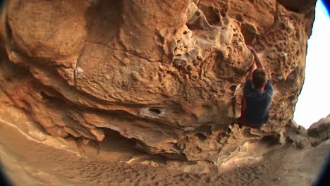 Fisheye-Of-A-Rockclimber-Making-His-Way-Along-The-Top-Of-A-Rockface