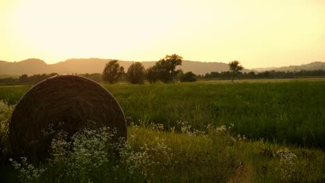 Haystack,-hay-bale-in-farm-field-country-landscape-during-sunset-at-golden-hour