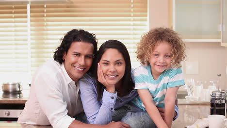 Family-smiling-at-the-camera-in-a-kitchen