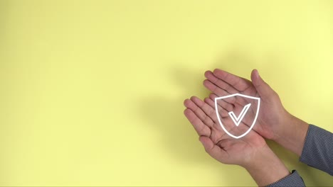 hands together show protection shield on yellow background