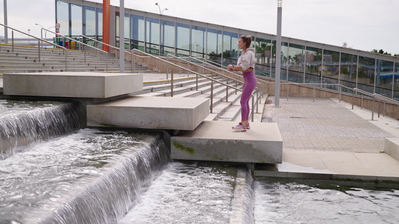 женщина занимается на городских лестницах с водопадами