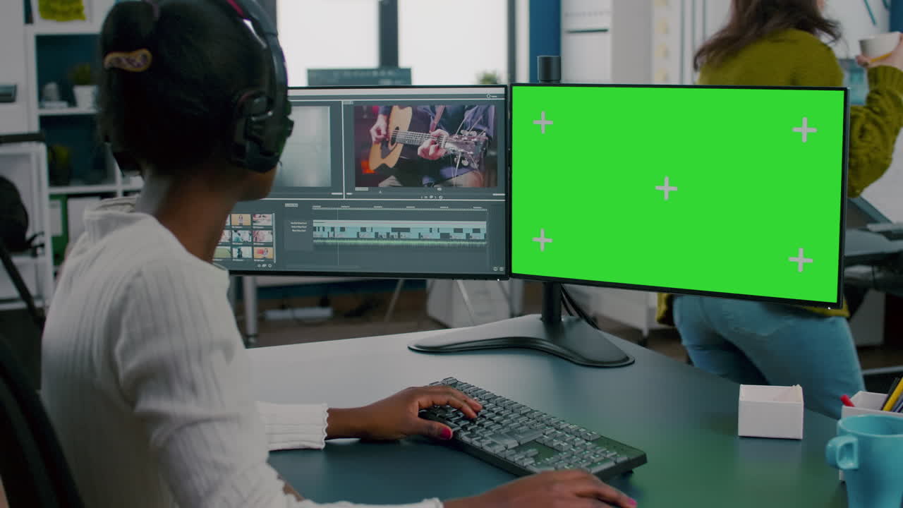 African woman videographer with headset processing film montage